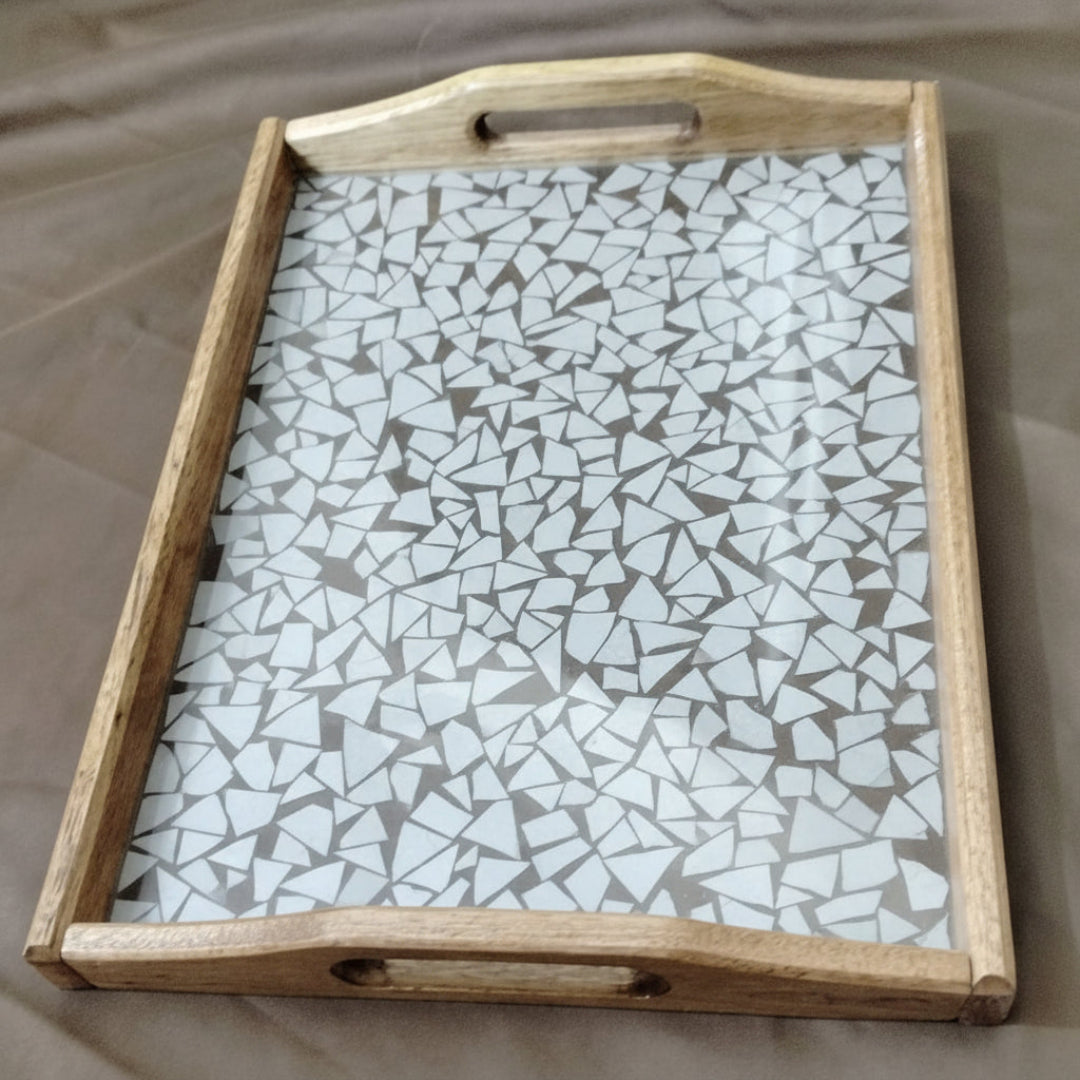 Wooden tray with a mosaic glass top on a beige surface
